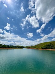 Lindo ceú azul com fundo para represa cheia de agua com cores vibrantes da natureza.