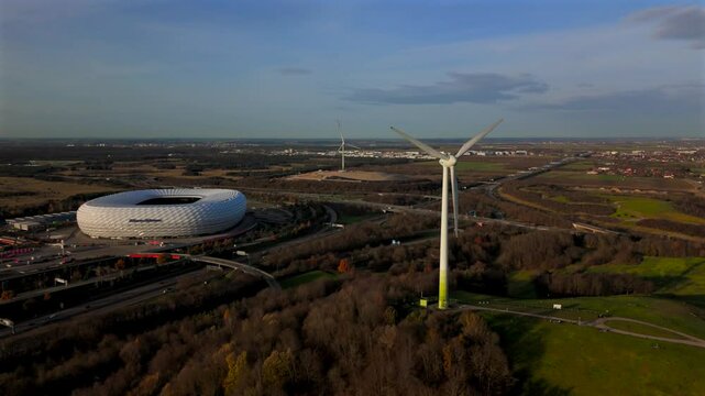 Windrad Froettmaninger Muellberg und Allianz Arena Muenchen, Deutschland Luftaufnahme. Frottmaninger Berg mit Blick auf Allianz Arena Luftbildansicht. Windkraftanlage Freimann. Munich Football Arena