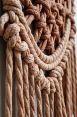 boho and artisanal design, interior decor. detailed closeup of handwoven mocha mousse macrame wall hanging with intricate knots and natural fibers in color of the year 2025 tones.