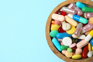 Various pills in a bowl on color background