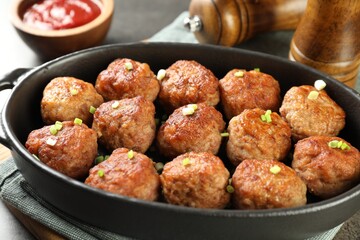 Tasty meatballs in baking dish on grey table, closeup