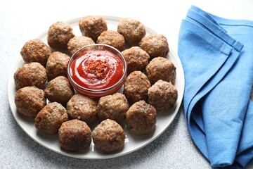 Delicious meatballs with ketchup and spices on light textured table, closeup