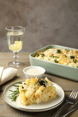 Tasty pasta casserole with cheese and broccoli served on wooden table