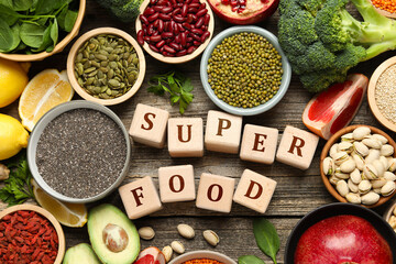 Superfood. Different healthy food products and cubes on wooden table, flat lay