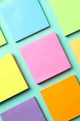 Top view of stack of colorful sticky notes on green background
