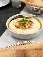Traditional Lebanese hummus with olive oil and spices served with fresh flatbread. Restaurant menus, cookbooks, or cultural food articles, Middle Eastern dining experiences.