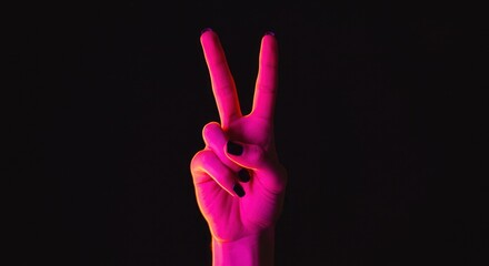 Obraz premium Neon pink peace sign hand gesture against black background