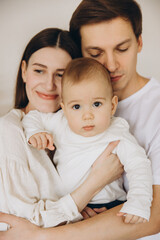 Young family embracing their baby with love and tenderness