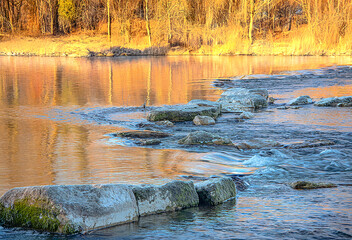 Flushing river water between the rocks in the warm morning light