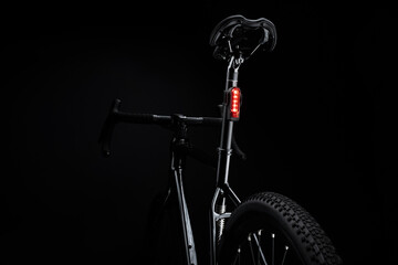 Close-up of illuminated bicycle tail light on black background