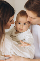 Young family embracing their baby with love and tenderness