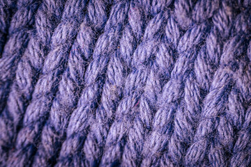 A macro view of dark blue knitted fabric showcasing the rich texture and thick yarn weave. The soft and intricate fibers highlight the cozy and durable material.