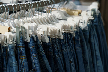 Fototapeta premium Denim hanging on racks in a retail store showcasing various styles and sizes