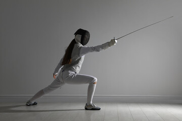 Fencer with epee practicing indoors. Combat sport