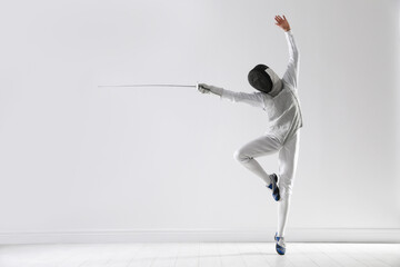 Fencer with epee practicing indoors, space for text