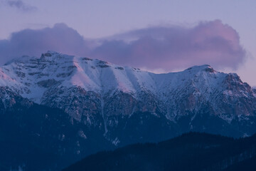A Beautiful Winter Sunset Panorama of the Bucegi Mountains (Romania) Covered by Snow and Thick Clouds