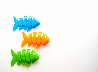 Blue, orange and green plastic happy fishes skeleton