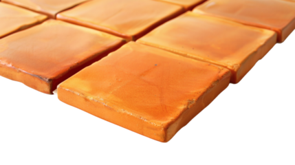 A patch of orange tile flooring with a warm tone on a white background