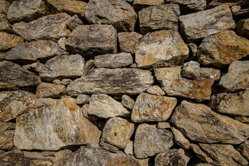 Stones texture of a medieval castle wall. Dry stone pattern of an ancient building made of rocks