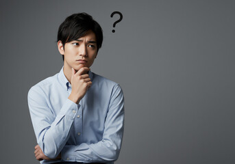 悩む男性、考えるポーズ、クエスチョンマーク、はてな、疑問符