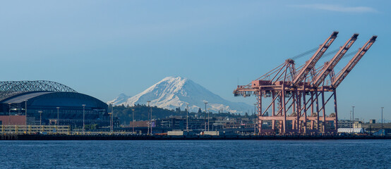 Port of Seattle cranes loom in the foreground with Mount Rainier and stadium in the background.