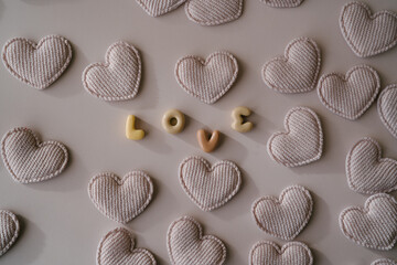 An arrangement of beige fabric hearts surrounding the word 