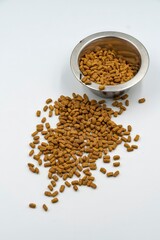 Dry food for domestic cats and dogs in a bowl on a white background