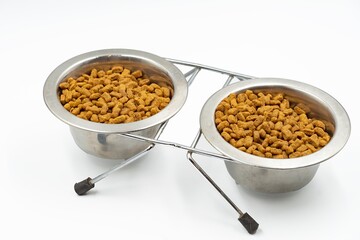 Dry food for domestic cats and dogs in a bowl on a white background