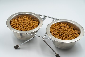 Dry food for domestic cats and dogs in a bowl on a white background