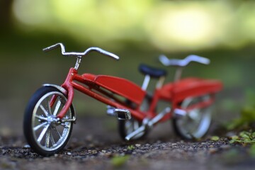 Obraz premium A small red toy bike sits on the ground, possibly waiting for its next adventure
