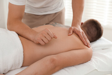 Massage therapist working with patient in clinic, closeup