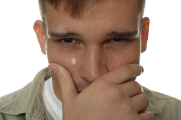 Distressed young man crying on white background