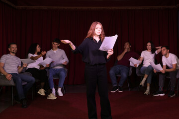 Professional actors reading their scripts during rehearsal in theatre