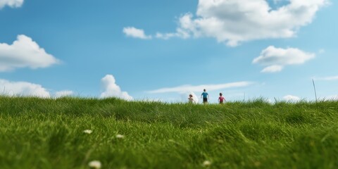 This vibrant landscape shows three silhouetted figures walking on lush green grass under a bright blue sky filled with fluffy white clouds, conveying freedom and joy.
