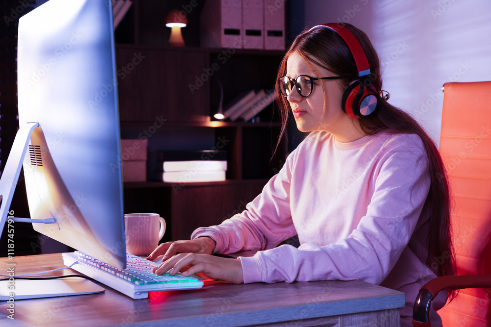 Wall mural Girl in headphones using computer keyboard at table indoors