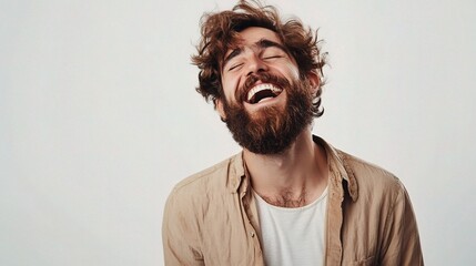 Fototapeta premium Handsome Man with Beard Laughing Against Light Background