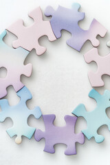 Obraz premium The paper multicolored puzzle pieces are assembled into a circle. Creative wallpaper, teamwork concept, unification
