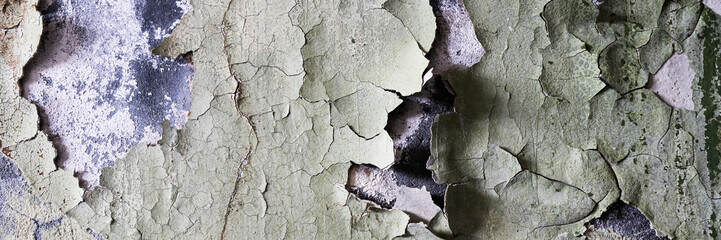 Peeling paint on the wall. Panorama of a concrete wall with old cracked flaking paint. Weathered...