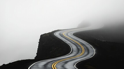   A winding path on a foggy mountain with a central yellow stripe