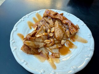 A cut piece of traditional French galette des rois or King cake, with fève inside. Cake made with puff pastry and creamy almond filling roll in circles shape.