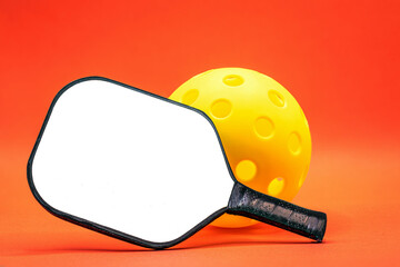 Pickleball Paddle with yellow Pickleball on a red background...room for text.