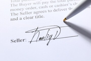 Signature and pen on paperwork, closeup view