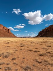 Naklejka premium Vast desert landscape with towering sandstone cliffs under a vibrant blue sky