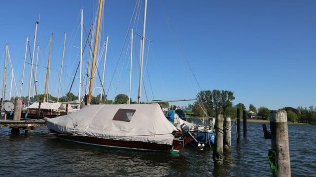 Sailboats docked at marina on sunny day