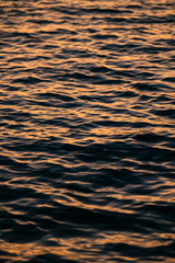 Reflejo abstracto en las ondas del agua, atardecer reflejado en la textura de las olas, brillo del sol sobre las olas del mar