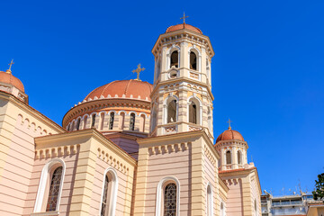 A large white and red building with a blue sky in the background