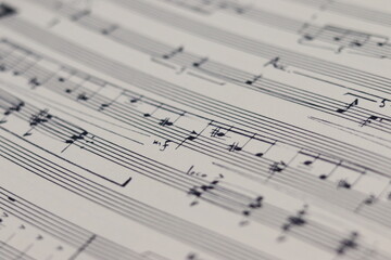 A white sheet with a musical partition. Musical notes on a sheet of music paper. Music notes as...