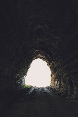 Obraz premium 岩がむき出しの暗い雰囲気のトンネル,