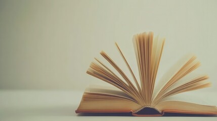 An open textbook on a white table invites reading and study, its pages filled with knowledge from literature and school texts