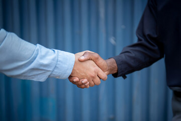 Businessman shaking hands, showing cooperation and success at a cargo port, container background.